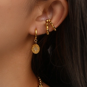 Detail of 18K gold plated hoop earrings with starburst pattern and bamboo-style ear cuffs