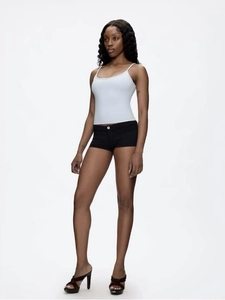Full body view of a model in a white U-neck slim crop tank top and black mini shorts