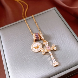 Dettaglio collana con ciondolo a croce placcata oro 18k con perle e pietre viola