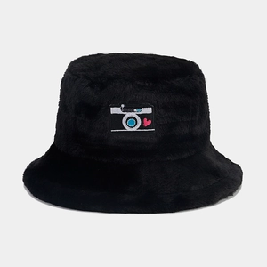 Detailed view of black faux fur bucket hat featuring a camera patch with heart detail