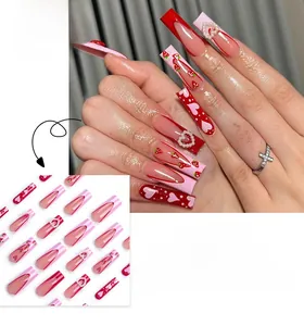 Detail of pink French press-on nails with 3D pearl hearts and strawberry patterns