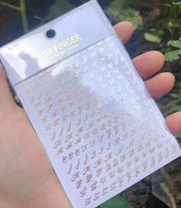 Close-up of rose gold 3D alphabet nail stickers with A-Z letters by POP FINGER