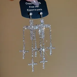 Sparkling silver cross tassel drop earrings with crystals on luxury jewelry card