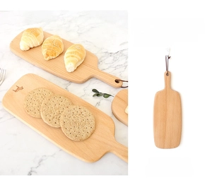 Detail of beech wood bread board showing the smooth surface and leather hanging strap