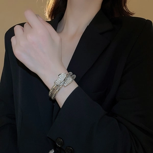 Close-up of sparkling silver snake-shaped bracelet with full rhinestone inlay on wrist