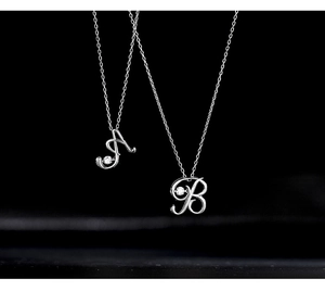 Detailed macro view of 925 silver letter A and B pendants with sparkling zircon stone