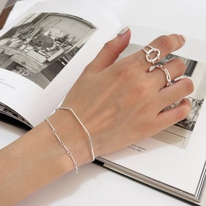 Minimalist S925 sterling silver twisted chain bracelet and layered rings on a hand