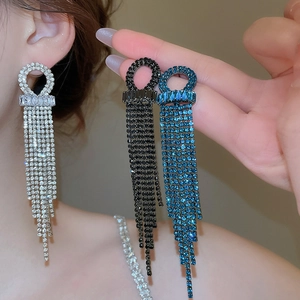 Detailed view of geometric tassel earrings featuring sparkling zircons in silver, black and blue