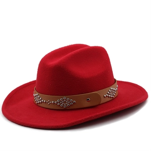 Detailed texture of red wool fedora with studded leather band in western style