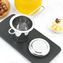 Detailed view of 304 stainless steel tea infuser with long handle on black tray