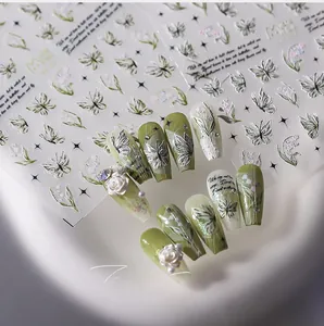 Macro view of 3D embossed nail stickers with green floral and butterfly motifs
