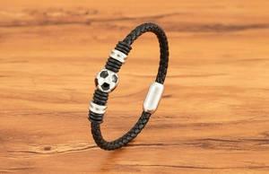 Close-up of leather braided football bracelet with magnetic clasp on wood