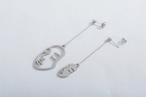 Détail des boucles d'oreilles visage en argent au design abstrait artistique