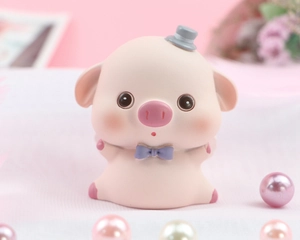 Close-up of cute pink piglet figurine wearing a grey hat and purple bowtie for cake decor