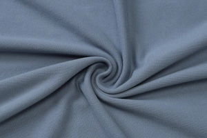 Detailed macro view of soft misty blue knit fabric texture showing premium material quality