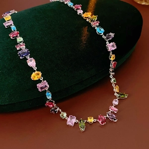 Detailed shot of multi-colored zircon stones necklace on a luxury green velvet jewelry box