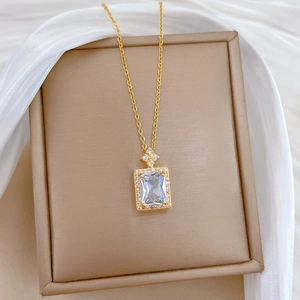 Macro shot of gold pendant featuring a large rectangular zircon with a halo of small crystals