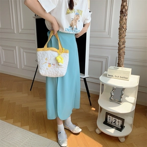 Detailed shot of white quilted handbag with yellow handles and floral embroidery detail