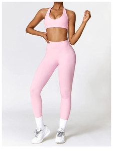 Detailed view of pink high-waisted yoga leggings and halter sports bra set on model