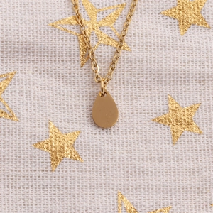Collier élégant en acier inoxydable doré avec pendentif goutte sur fond étoilé