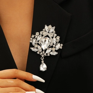 Macro shot of silver crystal crown brooch with tassels on a black suit lapel