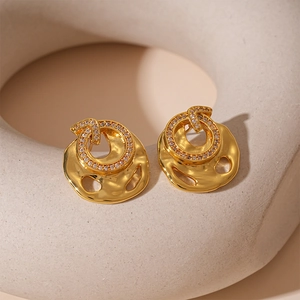 Macro detail of irregular lava texture gold stud earrings with cubic zirconia inlays