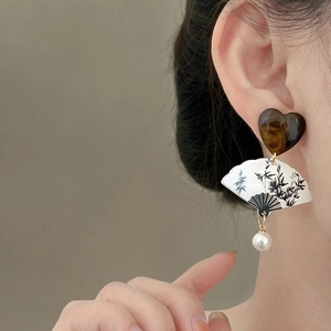 Detail of fan-shaped earring with ink bamboo pattern and elegant resin pearl tassels
