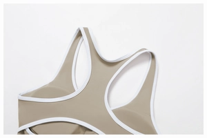 Dettaglio ravvicinato del reggiseno sportivo kaki con bordini bianchi a contrasto
