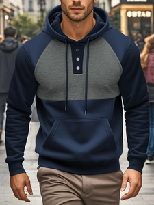 Detail of navy and grey colorblock hoodie showing three-button neckline and drawstring hood