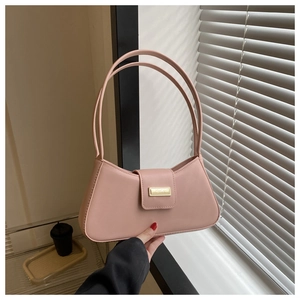 Detail of soft pink leather baguette bag with a sleek gold metallic rectangular buckle