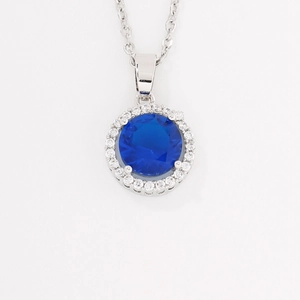 Elegant silver necklace with a round blue gemstone pendant surrounded by white zircons