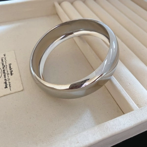 Détail d'un large bracelet argenté minimaliste avec finition métallique polie sur velours