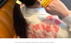Detail of high-elasticity braided hair ties in warm yellow tones worn on the wrist