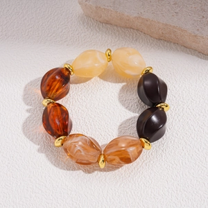 Macro view of vintage amber resin beaded necklace with golden spacer beads on a textured surface