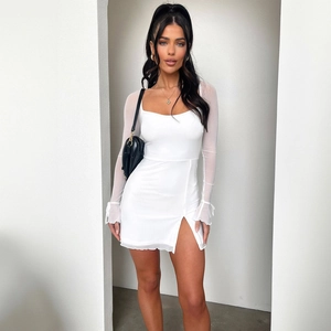 Detail of white mini dress featuring sheer mesh sleeves and stylish high slit side design