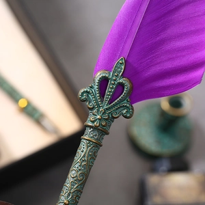 Detailed macro view of purple feather quill pen with vintage bronze metal embossed barrel