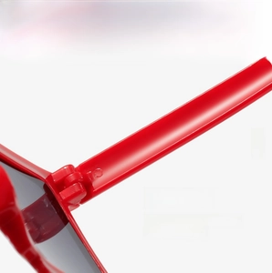 Close-up of a durable hinge structure on red mosaic block sunglasses with dark lenses