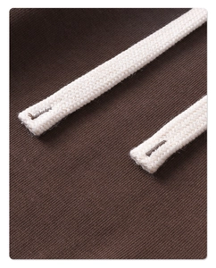 Macro de la tela de sarga marrón y detalles del cordón trenzado blanco