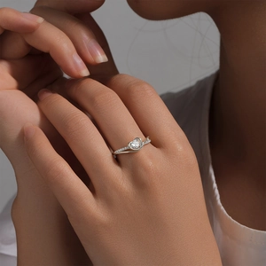 Macro detail of a silver S925 heart-shaped diamond engagement ring on a model's hand