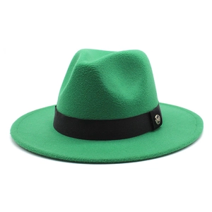 Detail of green wool fedora hat featuring black ribbon and gold metal M logo charm