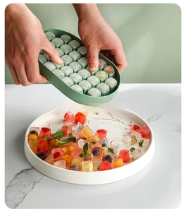 Press release action of green multi-grid ice cube mold with fresh fruit ice cubes