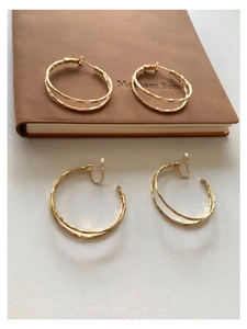 Detailansicht goldener Doppelring-Ohrringe als Stecker und Clip-On-Variante