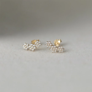 Macro detail of gold flower stud earrings with shimmering micro-pave cubic zirconia