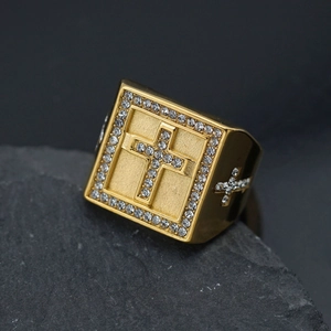 Detailed shot of golden square ring with cross design and clear zircon stones