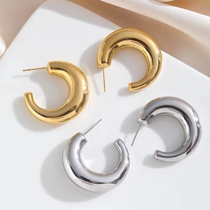 Thick C-shaped chunky hoop earrings in polished 18k gold and silver finishes