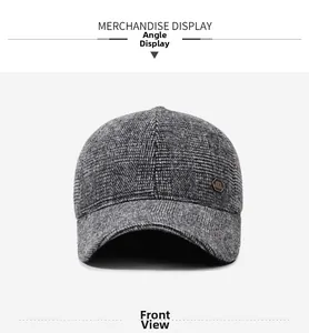 Detail of dark grey tweed winter baseball cap with side hexagonal metal logo m badge
