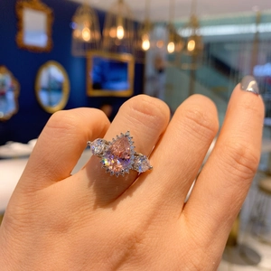 Exquisite pear-cut pink gemstone ring with side diamonds on model hand