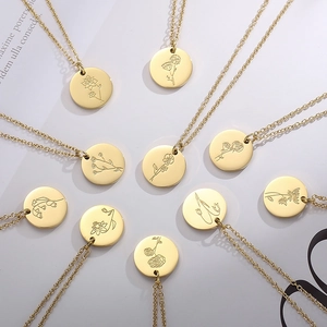 Détail de colliers médaillons dorés avec motifs floraux gravés pour chaque mois de naissance