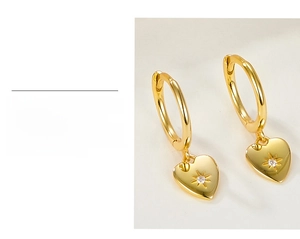 Detailed view of gold plated S925 silver heart earrings with starburst pattern and zircon