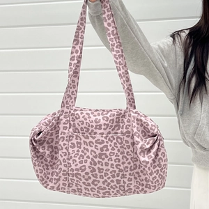 Dettaglio della grande borsa tote leopardata con tasca frontale e manici lunghi